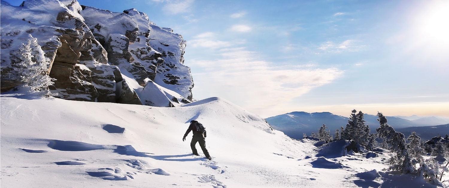 Man walking uphill on a snowy mountain